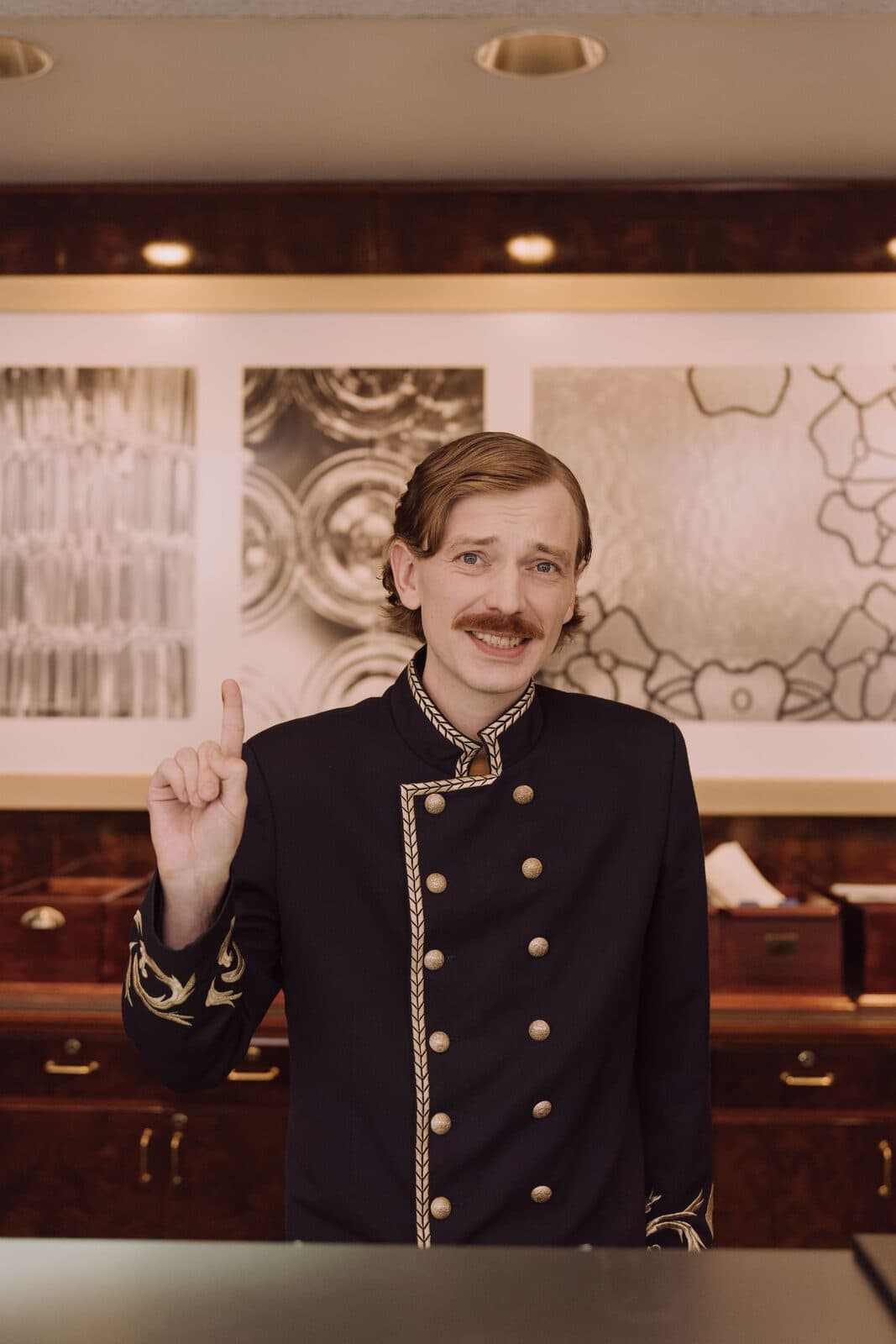 A concierge in uniform behind a hotel front desk