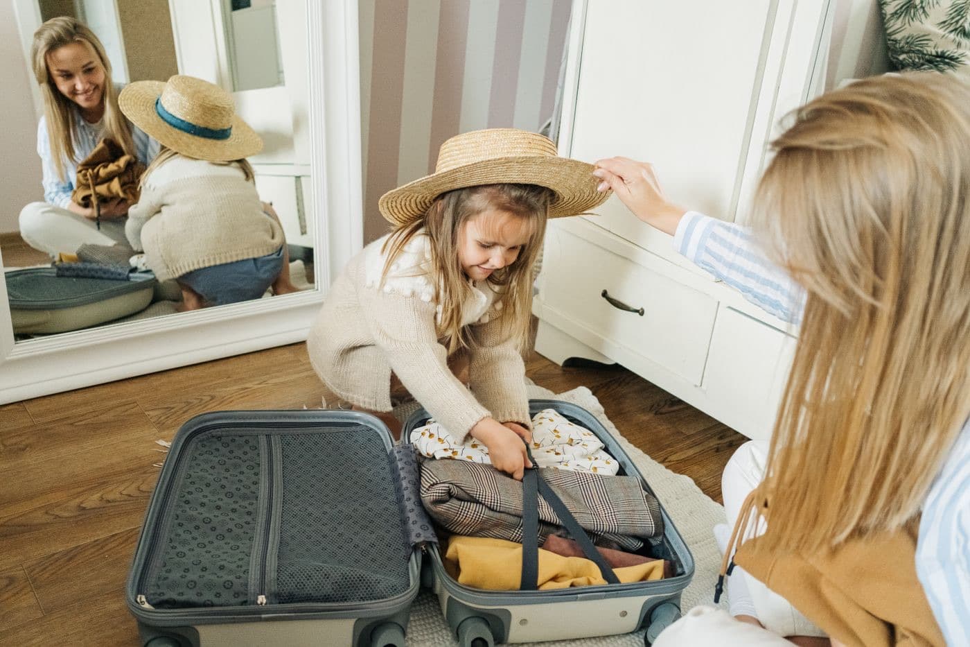 A mother and daughter packing a suitcase together for a trip